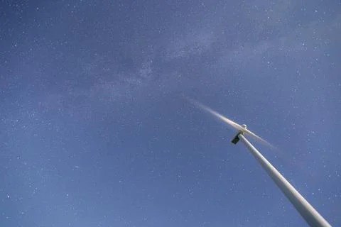 Low angle view of a wind turbine against the starry night sky Stock Photos