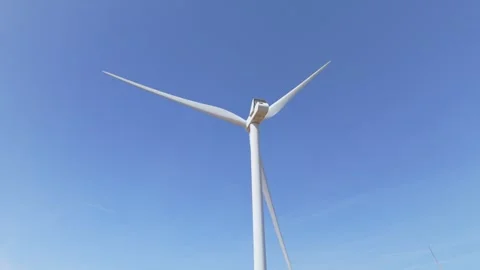 Low angle view of wind turbine’s propellers spinning with blue sky Stock Footage 340580040