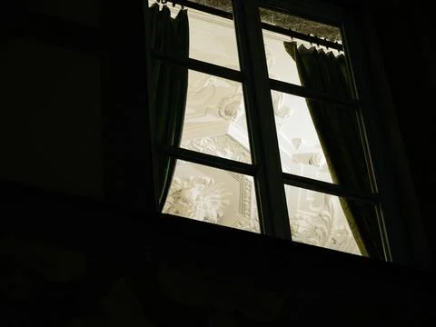 Low angle view of window with thick curtains and replication period moldings Stock Photos