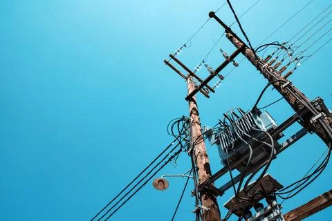 Low angle view of wooden utility poles with power lines and transformer aga.. Stock Photos