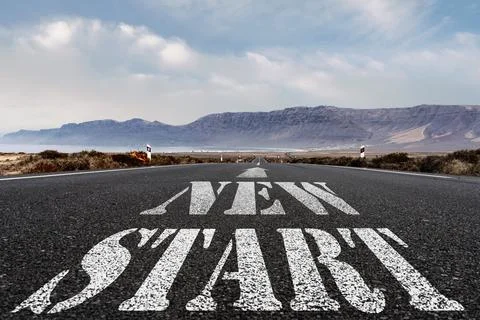 Low angle view of words NEW START and arrow symbol painted on asphalt road, new Foto stock