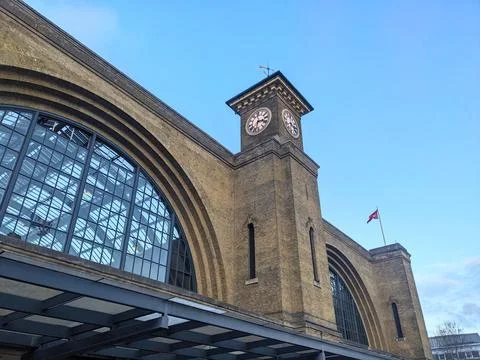 Low angle view of the yellow brick facade and clock tower of Kings Cross Station Stock Photos