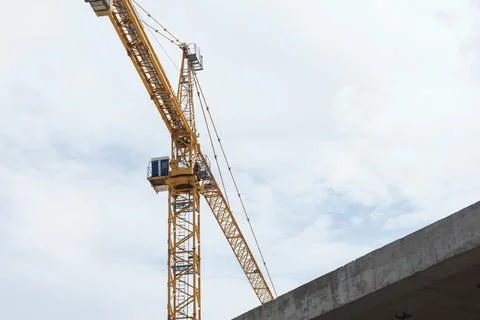 Low angle view of yellow construction tower crane boom extending horizontal.. Stock Photos
