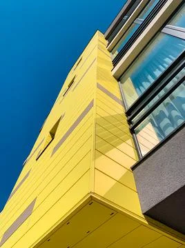 Low angle view of  yellow facade of a modern new and stylish apartment building. Stock Photos