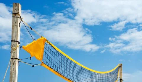 Low angle view   of yellow    filet beach volleyball  against blue sky .  Rel Stock Photos
