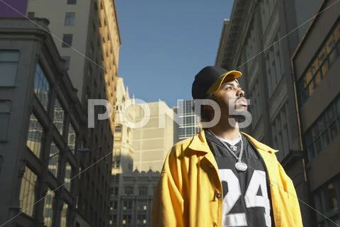 Low angle view of young African man standing in urban area Stock Photos