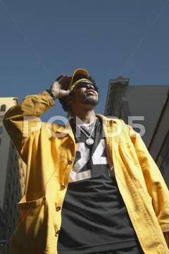 Low angle view of young African man standing in urban area Stock Photos