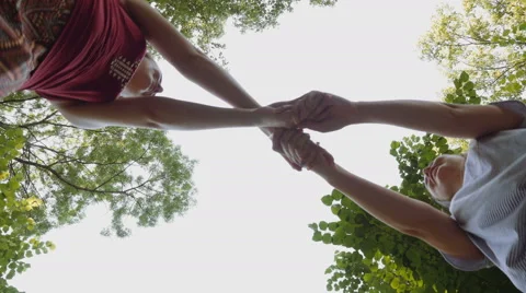 Low angle view of young attractive women spinning and playing Stock Footage 64794243