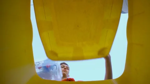 Low Angle View of Young Boy throwing used Bottles into bin and Recycling Plastic Stockbeeldmateriaal 127260507
