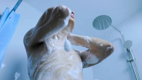 Low angle view of young male washing his soapy torso in the modern shower. Stock Footage 345531243
