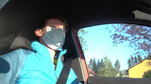 Low Angle View of Young Man Wearing Surgical Face Mask while Driving Car COVID19 Stock Footage 131047941