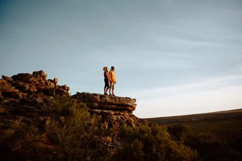 Low angle view of young man and woman standing looking at beautiful view after Stock Photos