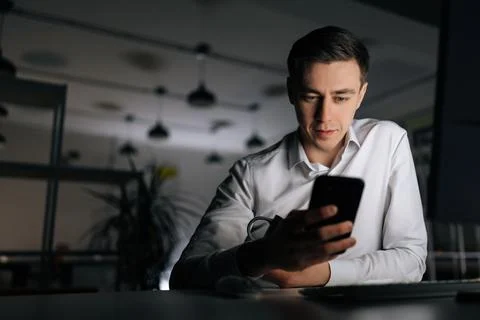 Low-angle view of young man chatting on mobile phone with friends at social Stock Photos