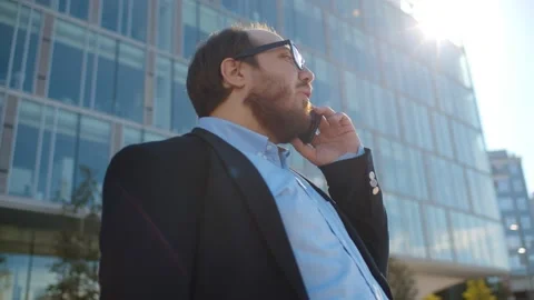 Low angle view of young obese businessman talking on smartphone in city outdoors Stock Footage 138213049