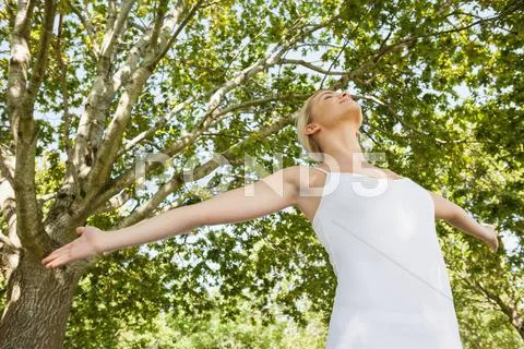 Low angle view of young woman doing yoga spreading her arms Stock Photos