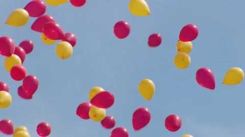 Low angle view zoom out of red and yellow balloons flying in air in stadium Video stock 104773986