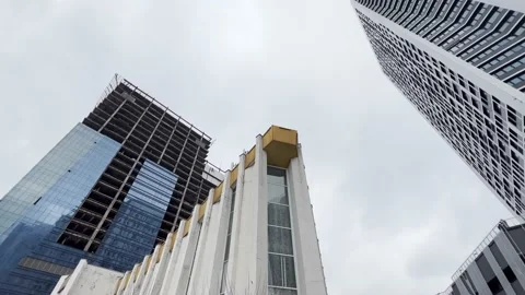 Low angle viewpoint of an Old and new buildings. tilt up from street to sky. Stock Footage 230705102