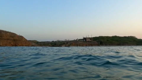 Low-angle water surface pov of punta aderci natural reserve at sunset 動画素材 279862759