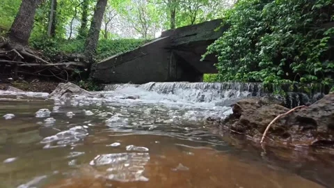 Low Angle Waterfall Bubbles Flowing Under Bridge Close-Up Water Texture 1080 Stock Footage 334084722