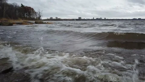 Low angle of waves crashing over river bed rocks Stock Footage 143197132