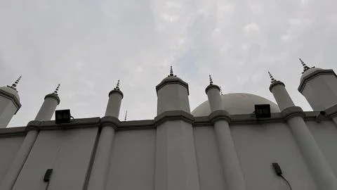 Low Angle of White Mosque with Minarets Under Cloudy Sky Exterior Foto stock