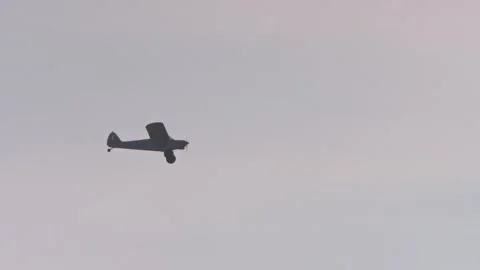 Low angle of white Super Cub plane flying across hazy sky in Africa Vídeo Stock 251899612