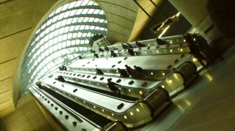 Low angle wide shot commuters on escalators under glass canopy at Canary Whar Stock Footage 707238