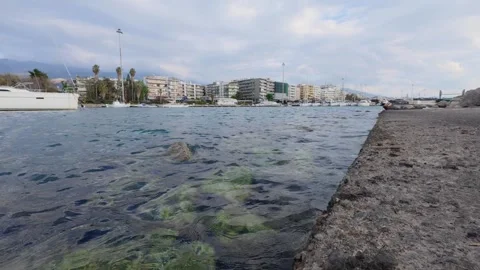 Low angle wide view of seaside promenade and clear coastal water Video stock 337459983