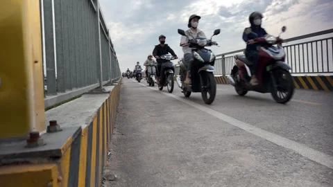 Low-angle-workers-riding-motorbikes-into-bac-ninh-industrial-park Stock Footage 340471881