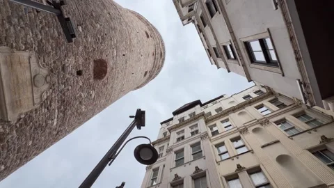 Low angle worms eye view looking up at the stone facade of Galata Tower Vídeos de archivo 340155093