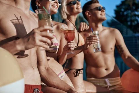 Low angle of young friends having rest in the swimming pool Foto stock