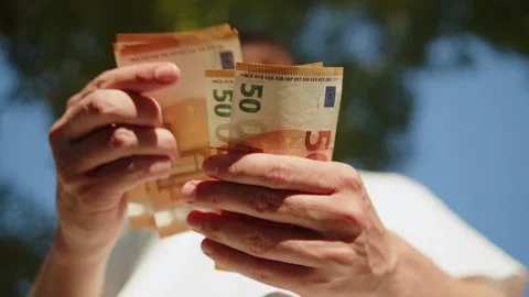 Low angle of a young man counting 50 Euro banknotes outdoors. Guy checking .. Vídeos de archivo 335652926