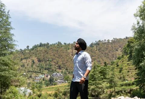 Low Angle of Young Sikh Man in Formal Attire Looking Up Posing in Mountain .. Stock Photos