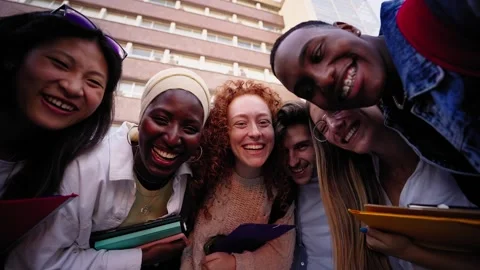 Low angle zoom. Group multiracial and diverse young students laughing looking at Stock Footage 276629819