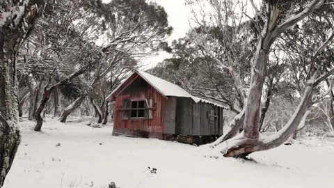 Low Angle Zoom Towards Snow Covered High Country Alpine Hut Low Aerial 4K Video stock 136868159