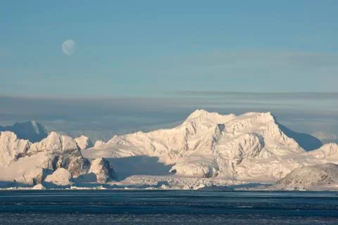 Low antarctic mountain on which the moon is visible. Stock Photos
