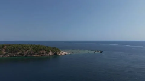 Low approach to a small forested islet off Aliki, Thassos, aerial Stock Footage 347176180