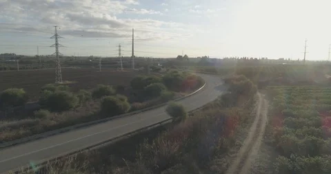 Low attitude tracking shot on a white sport car driving through open fields Stock Footage 100008610