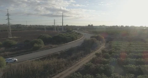 Low attitude tracking shot on a white sport car driving through open fields Stock Footage 100009580
