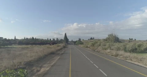 Low attitude tracking shot on a white sport car driving through open fields Stock Footage 100014305