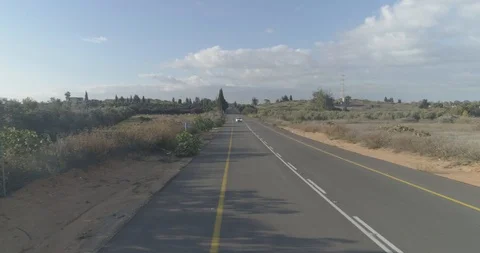 Low attitude tracking shot on a white sport car driving through open fields Stock Footage 100017281