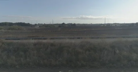 Low attitude tracking shot on a white sport car driving through open fields Stock Footage 100019201