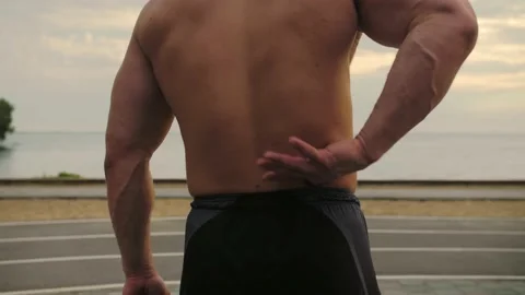 Low back pain in an athlete. Training in the street. Naked torso.Slow Motion Stock Footage 200118735
