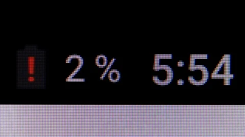 Low battery indicator of smartphone with a clock indicator. MACRO VIDEO where Stock Footage 84704033