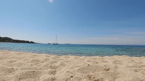 Low beach view of a sailing boat in Sithonia, Greece. Sunny day and clean Stock Footage 124018709