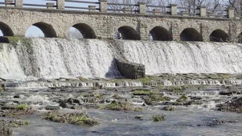 A low bridge across a small waterfall with a river in a rural area - front view 스톡 동영상 138200815