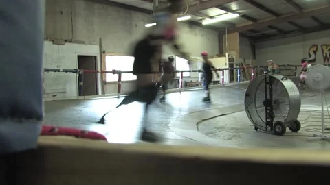 Low camera angle as skaters train on track, Texas Roller Derby Video stock 232958020