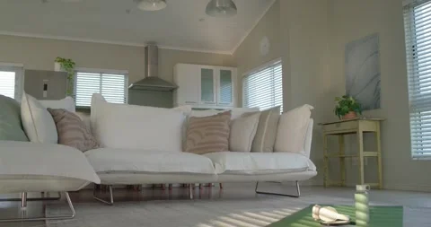 Low camera is panning as sun through blinds is shifting, revealing sofa green Stock Footage 343514697