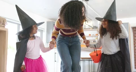 Low camera pulling back African American mom stepping holding hands pumpkin Stock Footage 345087163