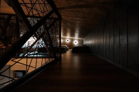 Low ceiling mezzanine beds with angular metal railing and warm light 스톡 사진